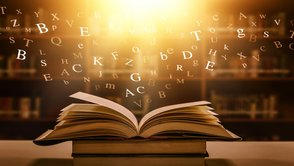 Buchstaben fliegen aus aufgeschlagenem Buch