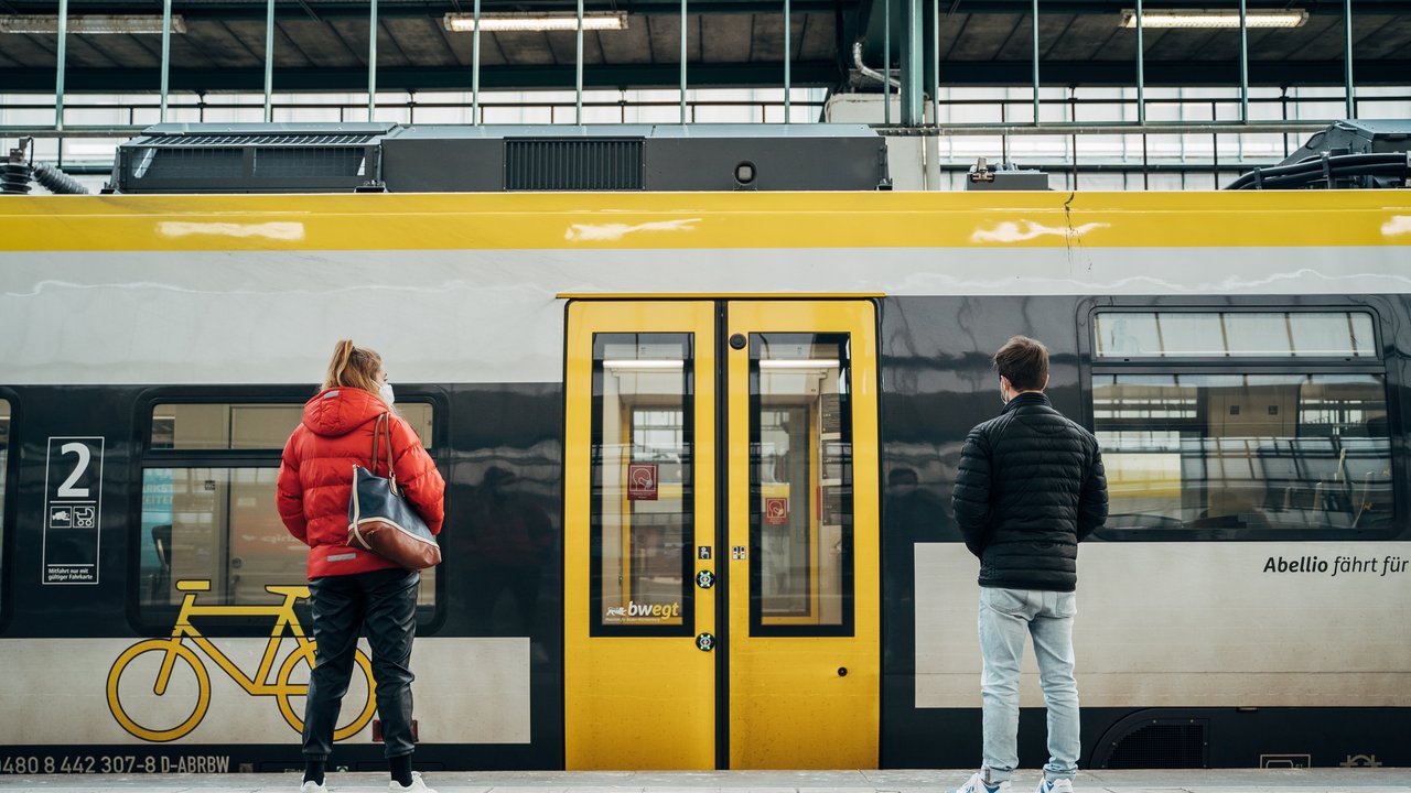 Zwei junge Menschen stehen am Zug