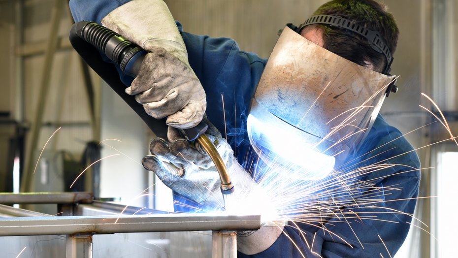 Industriearbeiter mit Schutzkleidung beim Schweißen Bild zeigt Industriearbeiter mit Schutzkleidung