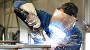 Industriearbeiter mit Schutzkleidung beim Schweißen Bild zeigt Industriearbeiter mit Schutzkleidung