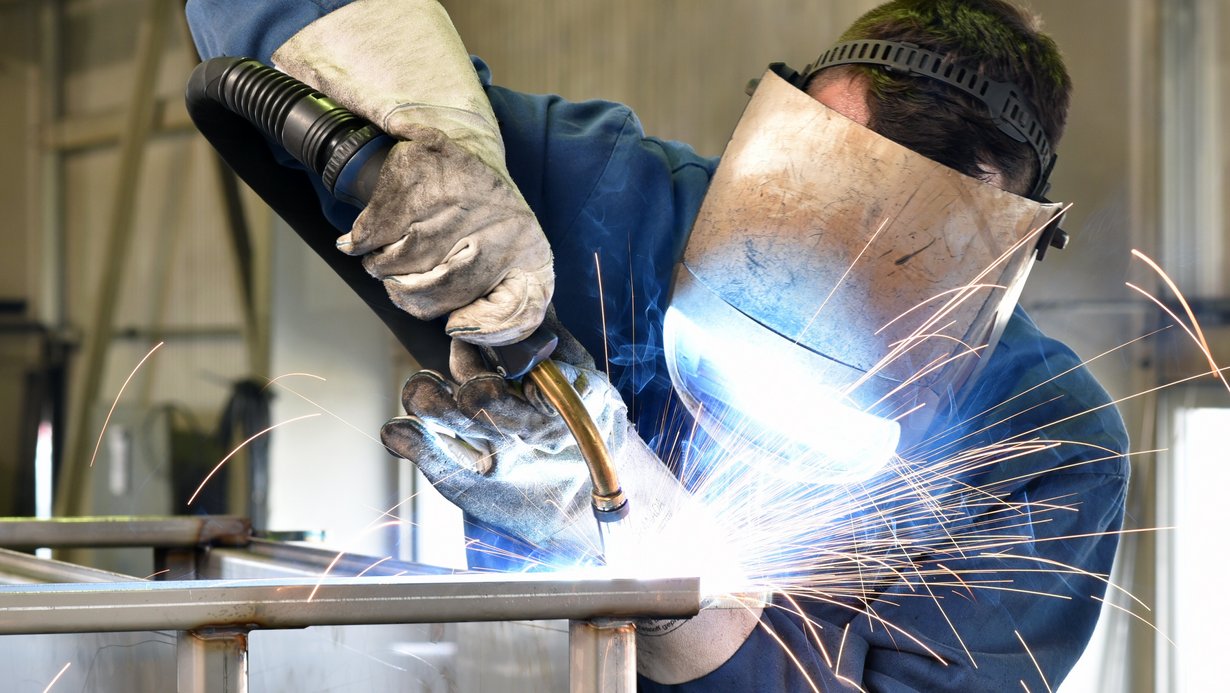 Industriearbeiter mit Schutzkleidung beim Schweißen Bild zeigt Industriearbeiter mit Schutzkleidung