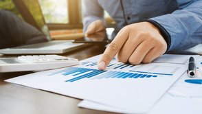 Mitarbeiter prüft Unterlagen an einem Schreibtisch