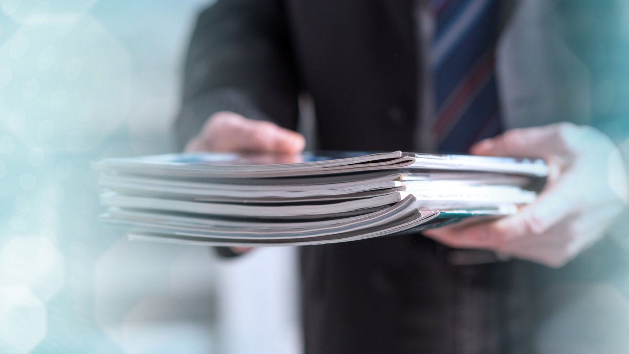 Bild zeigt Mann mit Zeitschriften