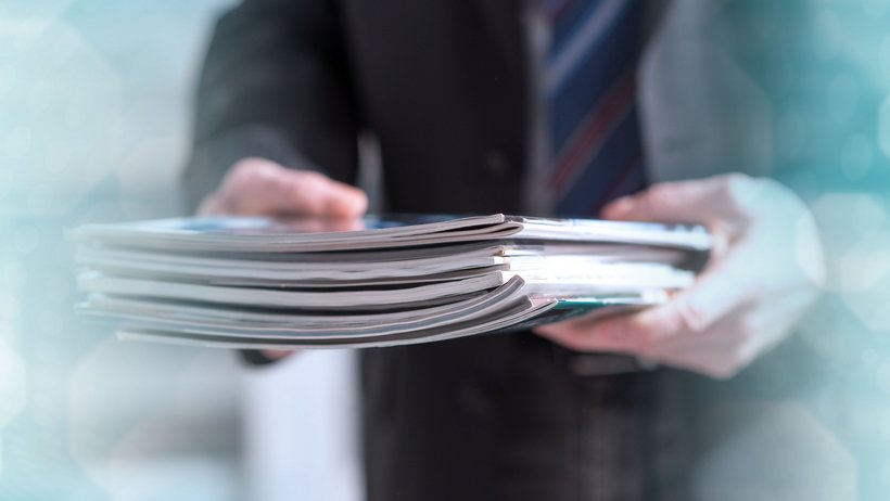 Bild zeigt Mann mit Zeitschriften