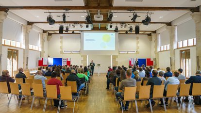 Mehrere Personen sitzen bei einem Vortrag