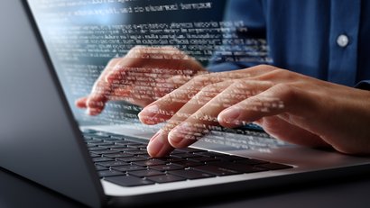 Hände am Laptop die einen Text schreiben