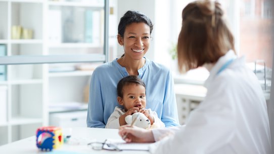 Eine Mutter mit einem Kleinkind bei einer Ärztin