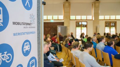 Mehrere Personen sitzen bei einem Vortrag