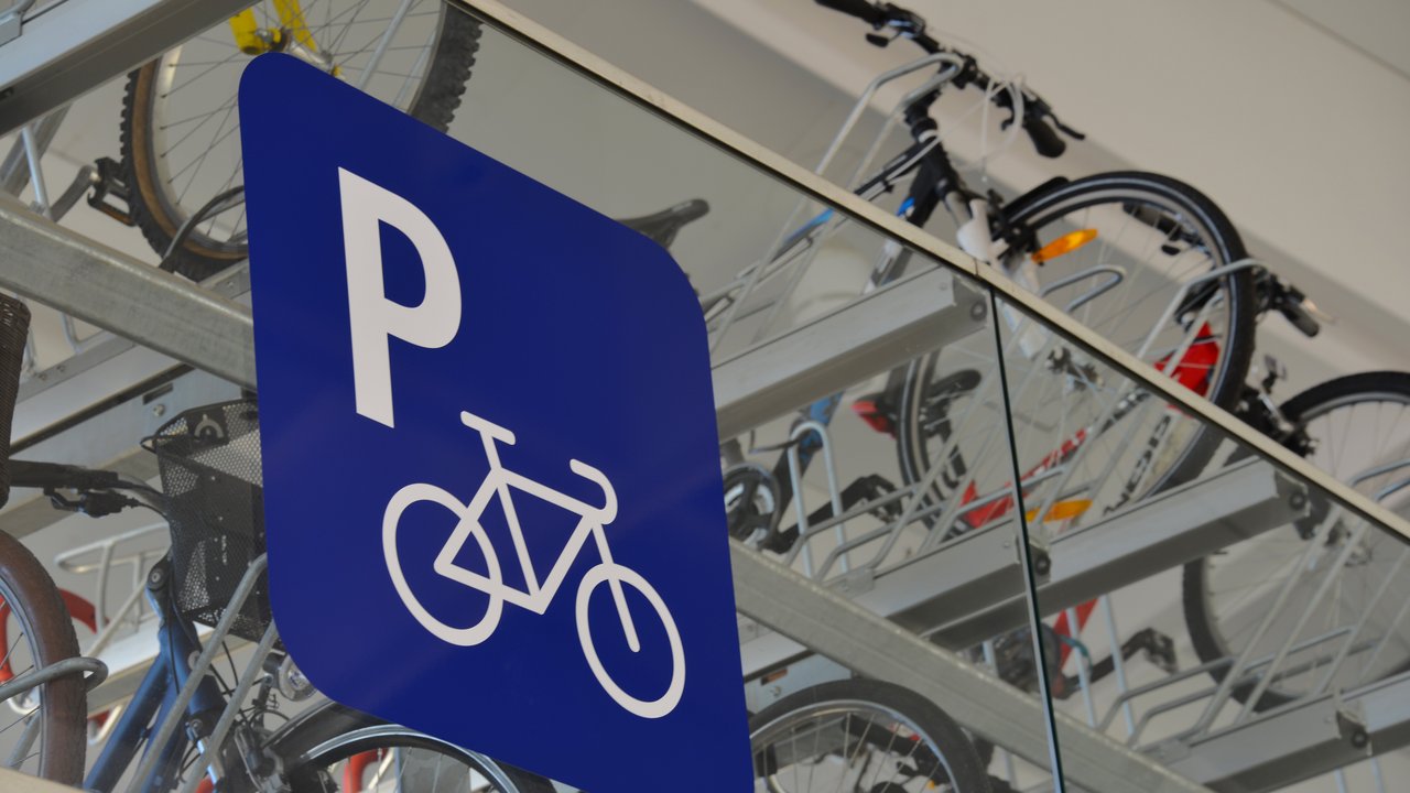 Fahrradparkplatz mit blauem Parkplatzschild darauf ein weißes "P" und ein weißes Fahrrad