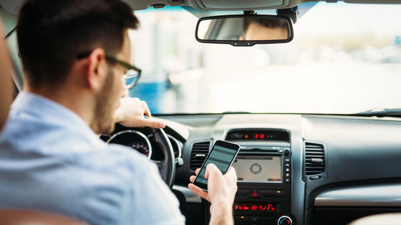 Fahrer versendet Handynachrichten, während er am Steuer eines Fahrzeugs sitzt