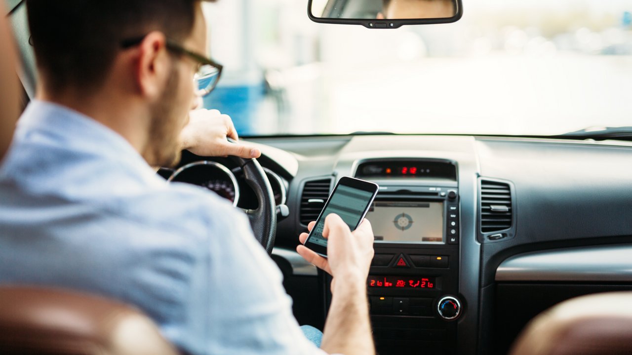 Fahrer versendet Handynachrichten, während er am Steuer eines Fahrzeugs sitzt