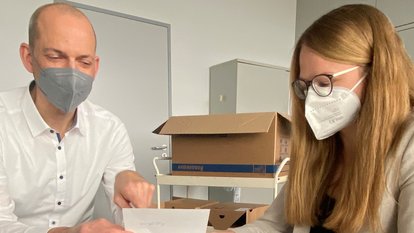 Zwei Mitarbeitende sichten Unterlagen