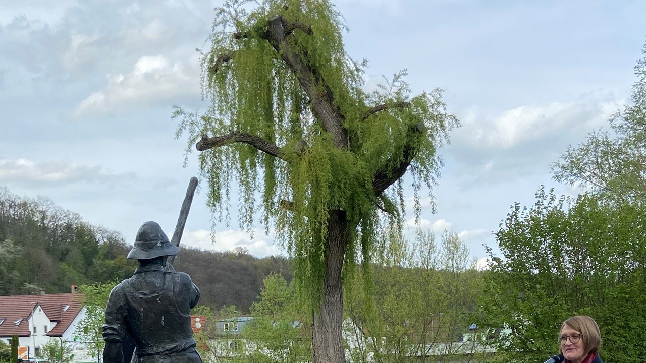 Frau Bürgermeisterin Braun steht am Rednerpult und hält Ihre Brüßungsrede, dahinter Stehtische, neben Ihr eine Skulptur
