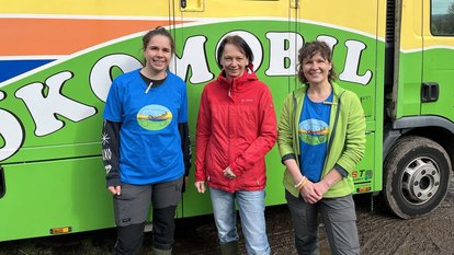 Regierungspräsidentin Bay mit zwei Mitarbeiterinnen des Ökomobils vor dem Fahrzeug des Ökomobils
