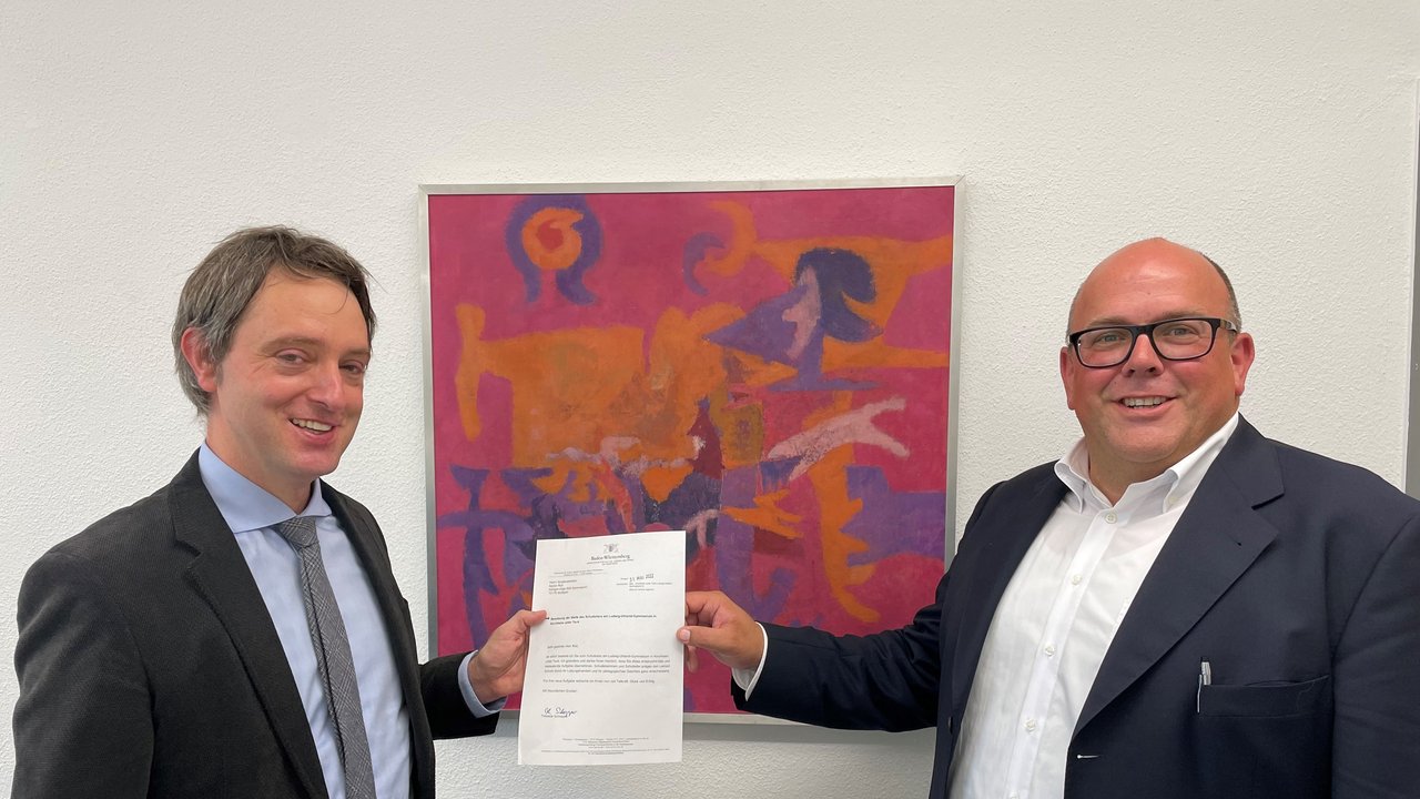 Bild zeigt die Übergabe des Bestellungsschreibens an Martin Roll