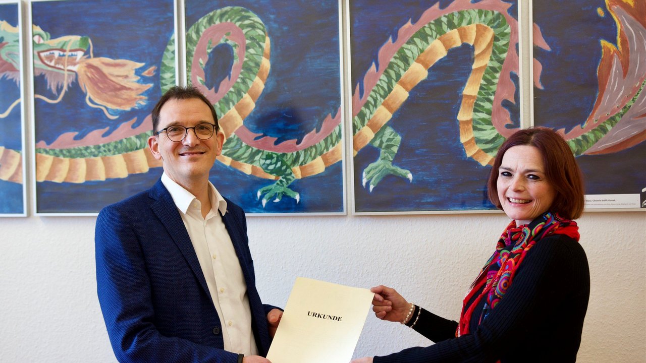 Melanie Stumpf, zuständige Referentin am Regierungspräsidium Stuttgart, überreicht Tim Praßel das Bestellungsschreiben von Kultusministerin Theresa Schopper
