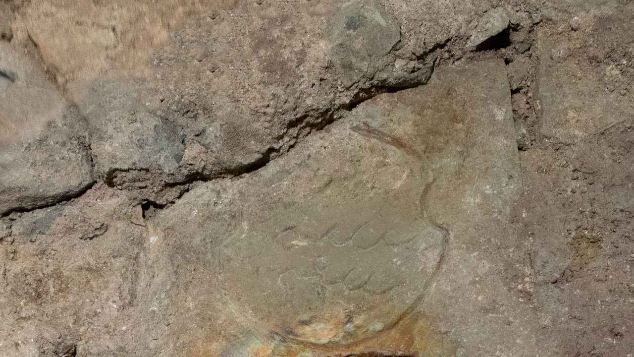 Freigelegter Grundstein des Neuen Lusthauses. Deutlich zu erkennen sind Gründungsjahr und württembergisches Wappenschild sowie die im Hohlraum gestellte bronzene Bronzeplatte mit eingravierter Urkunde