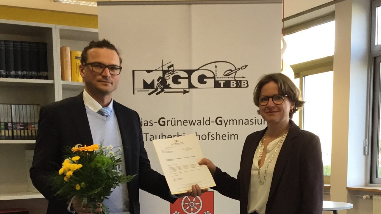 Kristina Klemm überreicht Sebastian Link das Bestellungsschreiben vom Kultusministerium