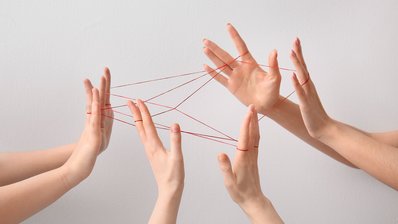 Bild zeigt 6 mit Fäden verschlungene Hände