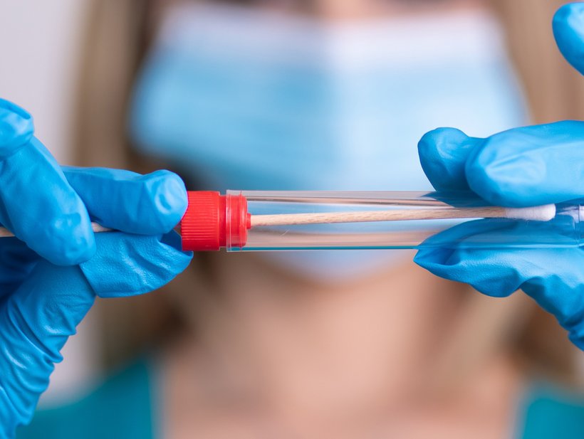 Krankenschwester mit Schutzmaske hält einen Virus-Testkit