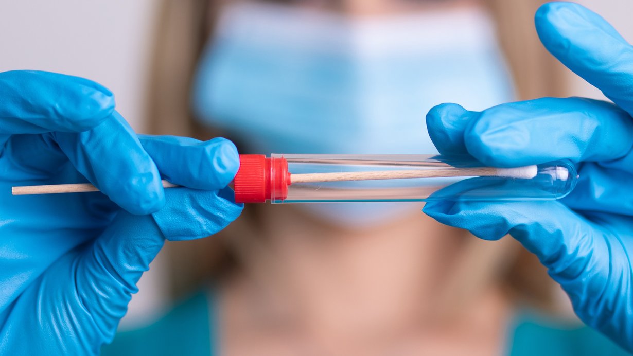 Krankenschwester mit Schutzmaske hält einen Virus-Testkit