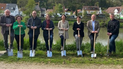 Alle Teilnehmer stehen in einer Reihe mit einem Spaten in der Hand