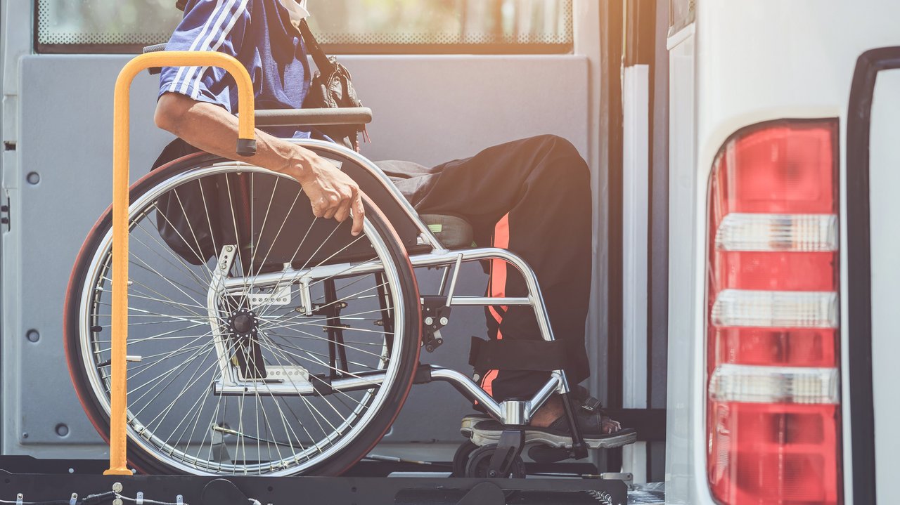 Rollstuhlfahrer der mit einer Hebebühne den Bus besteigen kann