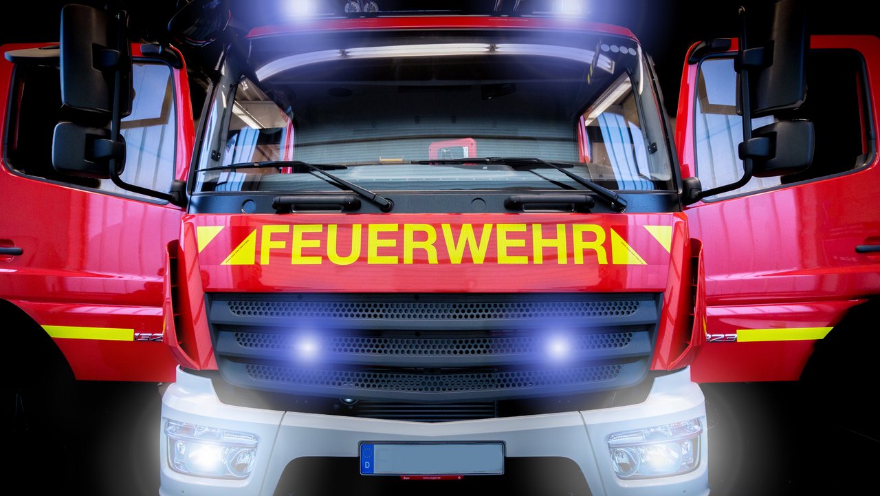 Feuerwehrfahrzeug LF10 mit Blaulicht und Frontblitzer vor schwarzem Hintergrund