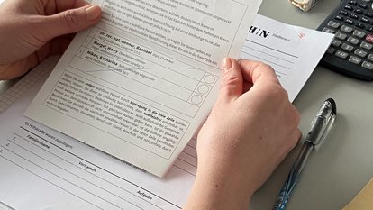 Eine Mitarbeiterin prüft Unterlagen