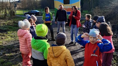 Kinder stehen im Kreis um Regierungspräsidentin Bay, dahinter das Ökomobil