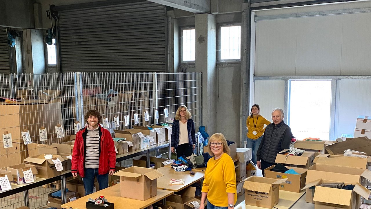  Kleiderspenden in der LEA Ellwangen - Ehrenamtliche und der Ehrenamts-koordinator der Caritas Ost-Württemberg, Pascal Haug (vorne links)