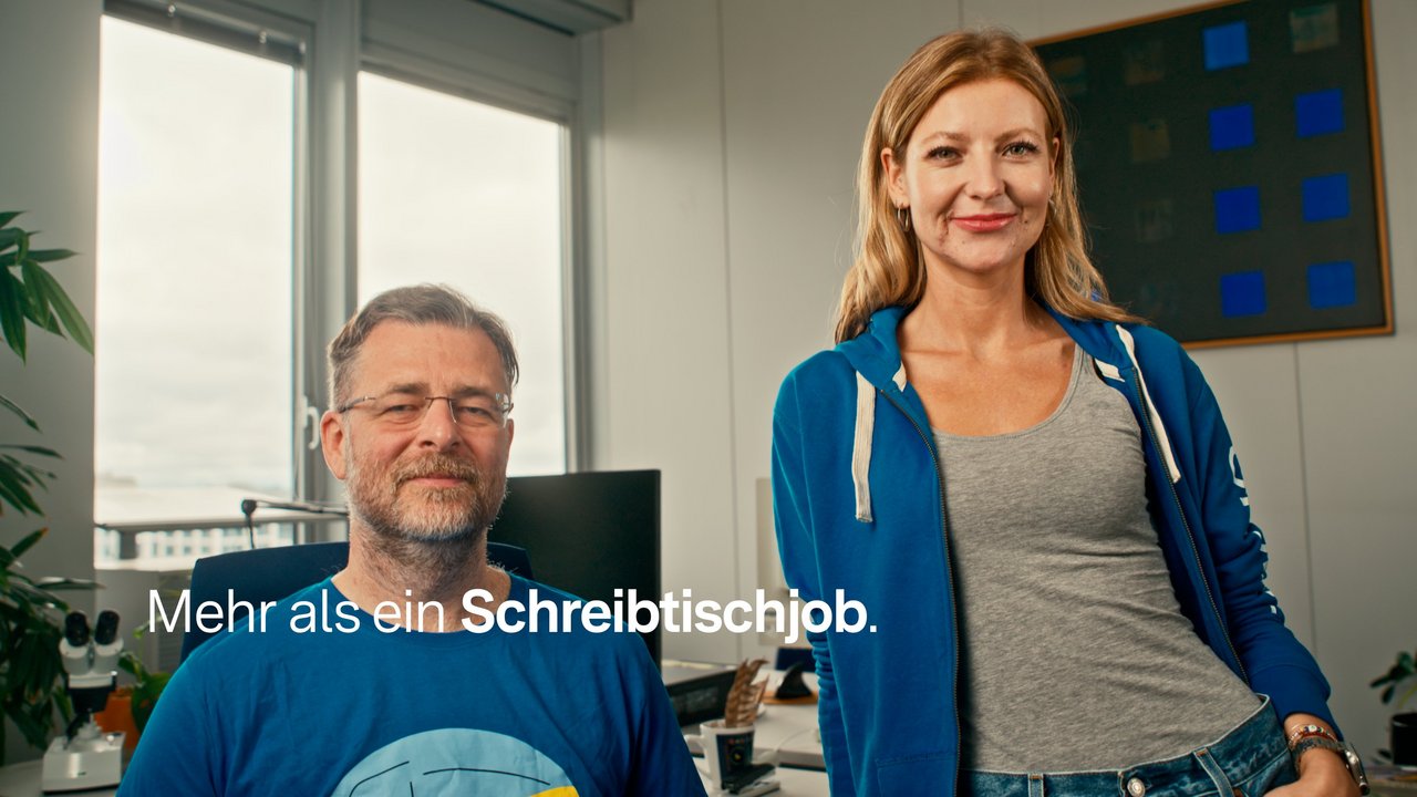 Bild zeigt zwei Personen in lässiger Kleidung in einem Büro