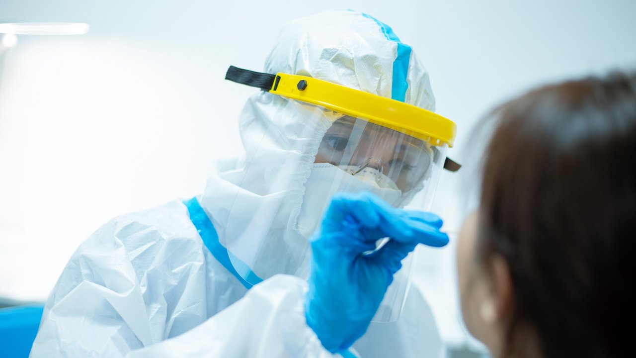 Frau die einen Coronatest bei einer Person durchführt