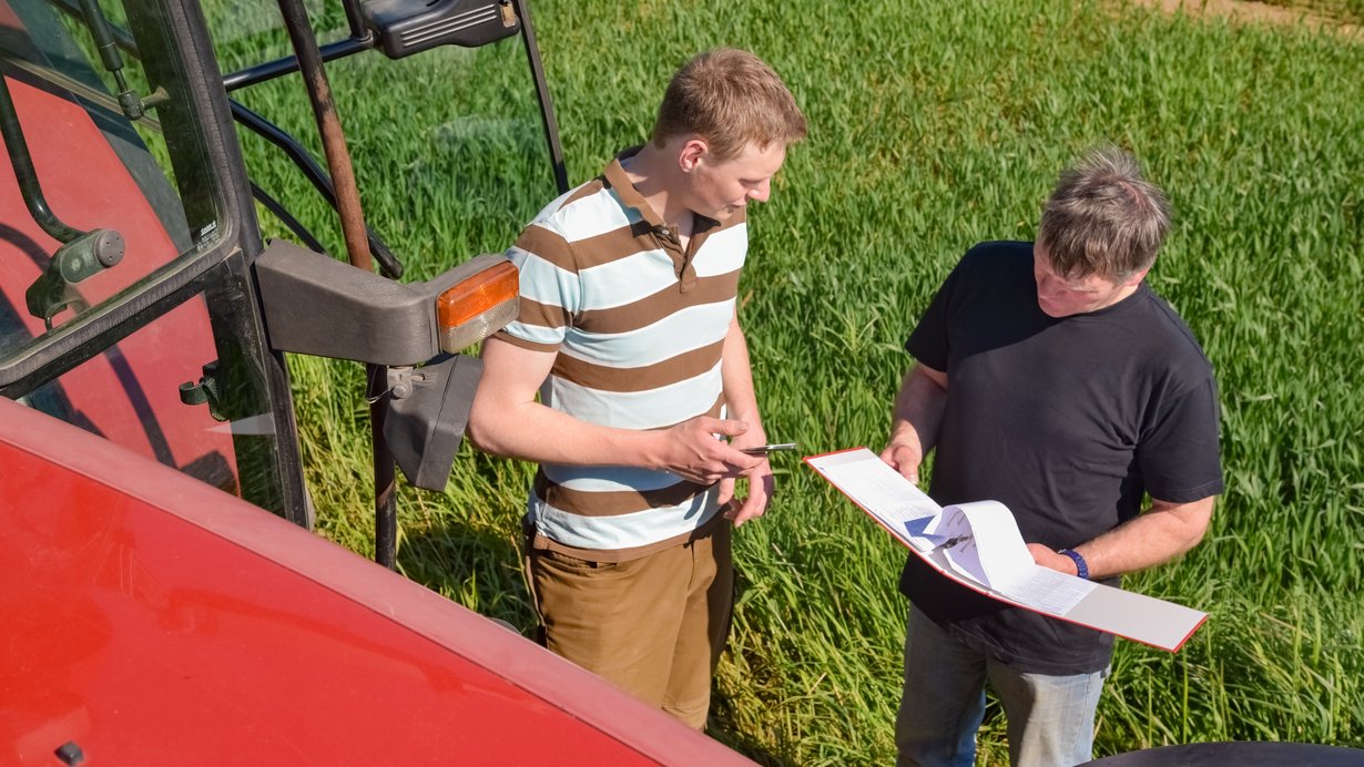 Landwirt und Mitarbeiter besprechen sich auf dem Feld