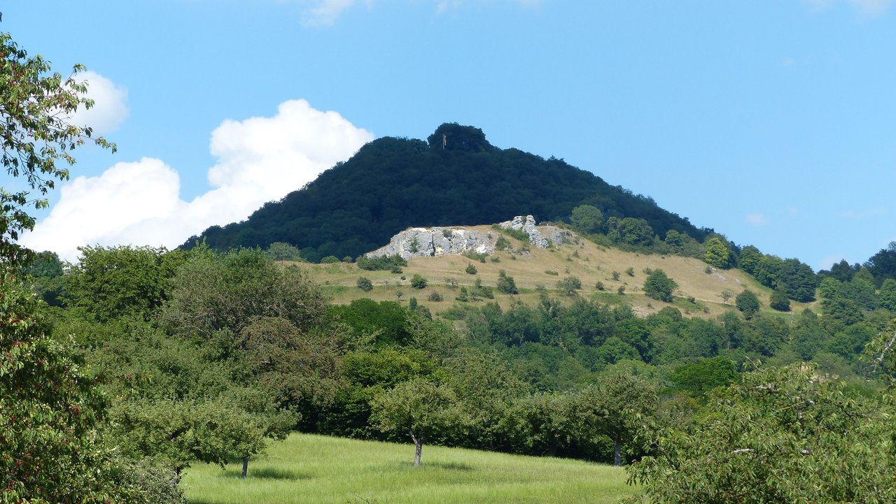 Blick zum Naturschutzgebiet Spielburg (im Mittelgrund) mit Felsen und Kalk-Magerrasen, dahinter der Hohenstaufen