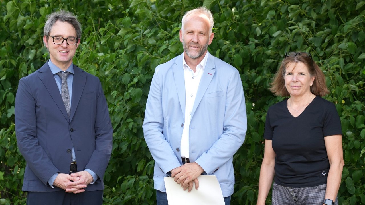 Michael Quade (links), Schulreferent am Regierungspräsidium Stuttgart, überreicht Ralph Mülherr (Mitte) im Beisein der kommissarischen Schulleiterin Monika Scheubel (rechts) das Bestellungsschreiben von Kultusministerin Theresa Schopper. 