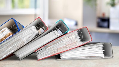 Bild zeigt 5 liegende Aktenordner