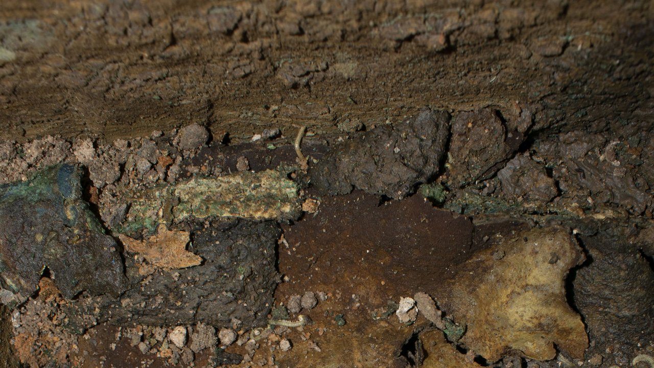  Detail Leder (evtl. Lederetui) - Erkennbar ist eine Oberfläche aus Leder mit Nähten. Inhalt und das mögliche Etui waren jedoch nur sehr schlecht erhalten