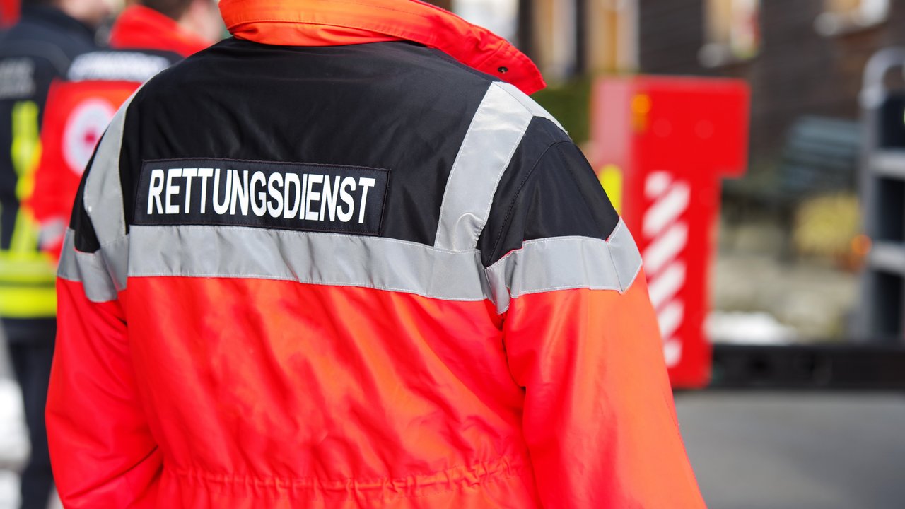 Bild zeigt Rückansicht einer Person mit Rettungsdienstjacke