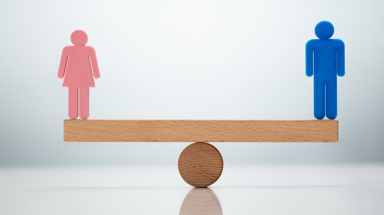 Eine Frau und ein Mann stehen auf einer Wippe