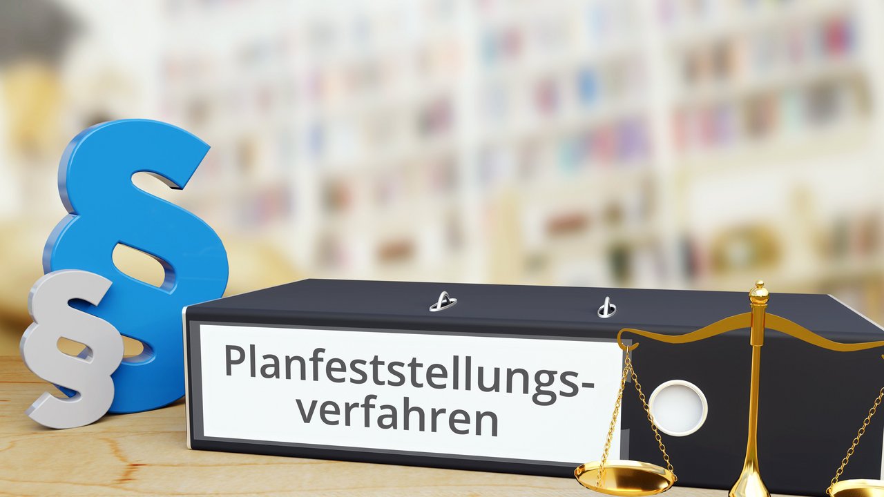 Ordner auf Schreibtisch mit Beschriftung neben Paragraf und Waage