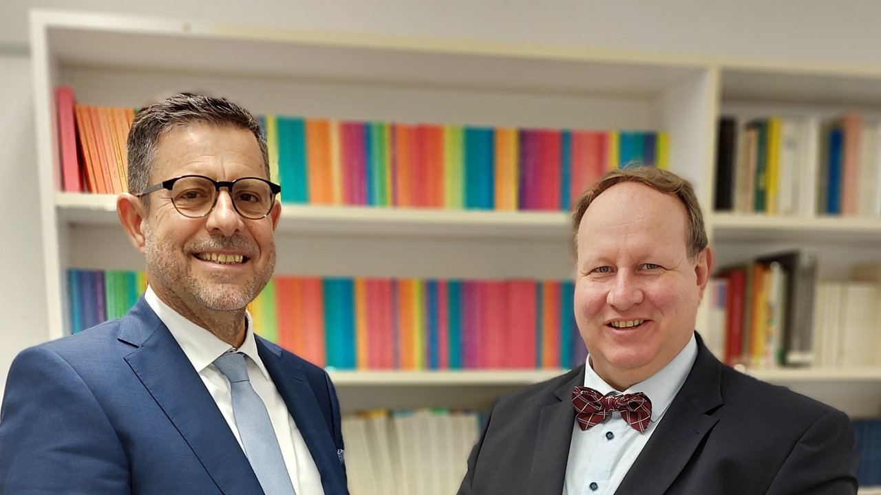 Jörg Brehmer (rechts), zuständiger Referent am Regierungspräsidium Stuttgart, überreicht Jens Kleindienst (links) das Bestellungsschreiben von Kultusministerin Theresa Schopper