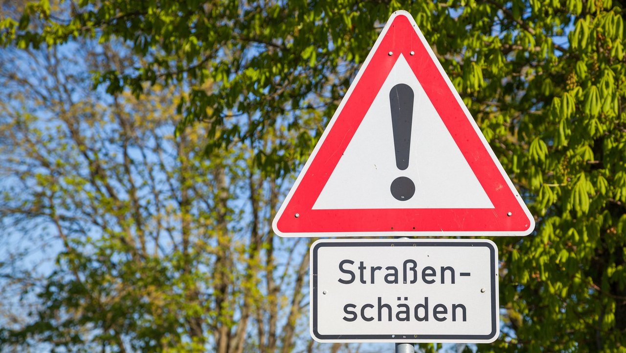 Bild zeigt Warnschild "Straßenschäden"