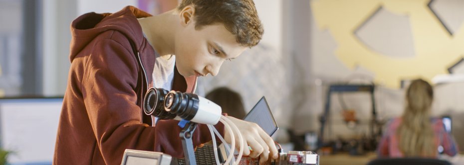Junge arbeitet an Roboter Junge arbeitet an voll funktionsfähigem programmierbaren Roboter