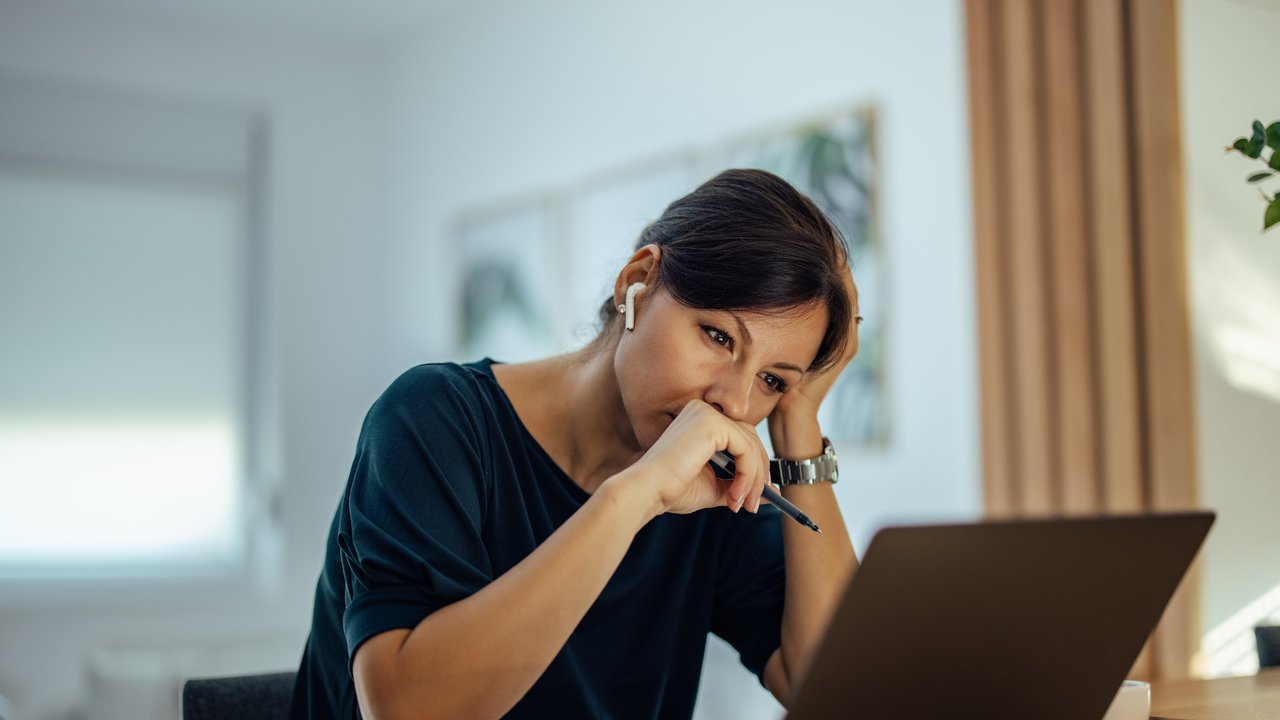 Frau sitzt zuhause vor einem Laptop