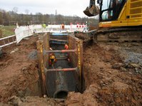 Baustelle mit Kran und weißer Abschrankung