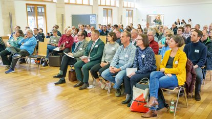 Mehrere Personen sitzen bei einem Vortrag in einem Saal