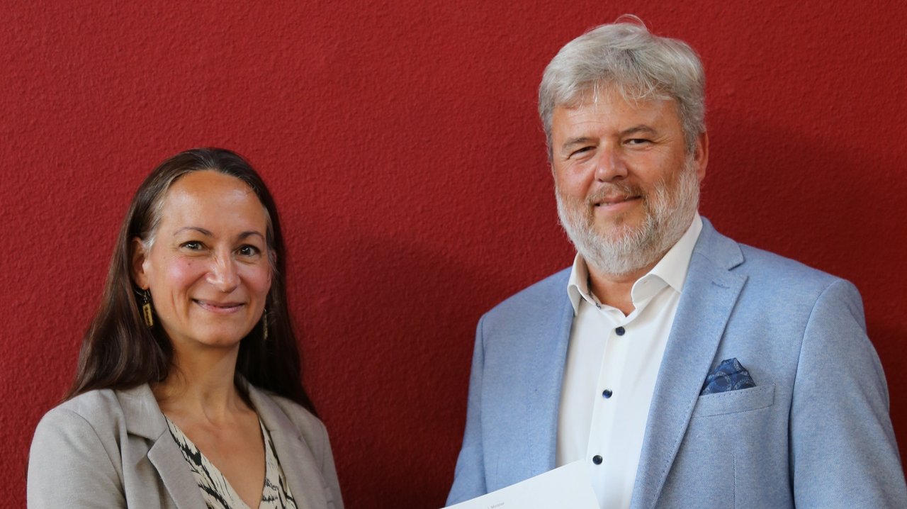 Emanuela Buyer (links), zuständige Referentin am Regierungspräsidium Stuttgart, überreicht Dr. Michael Hoffmann (rechts) das Bestellungsschreiben von Kultusminister Andreas Jung.