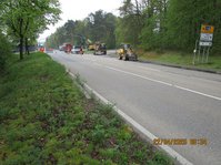 Straße auf der Baufahrzeuge stehen, Arbeiter, ein Straßenschild mit Wegangaben