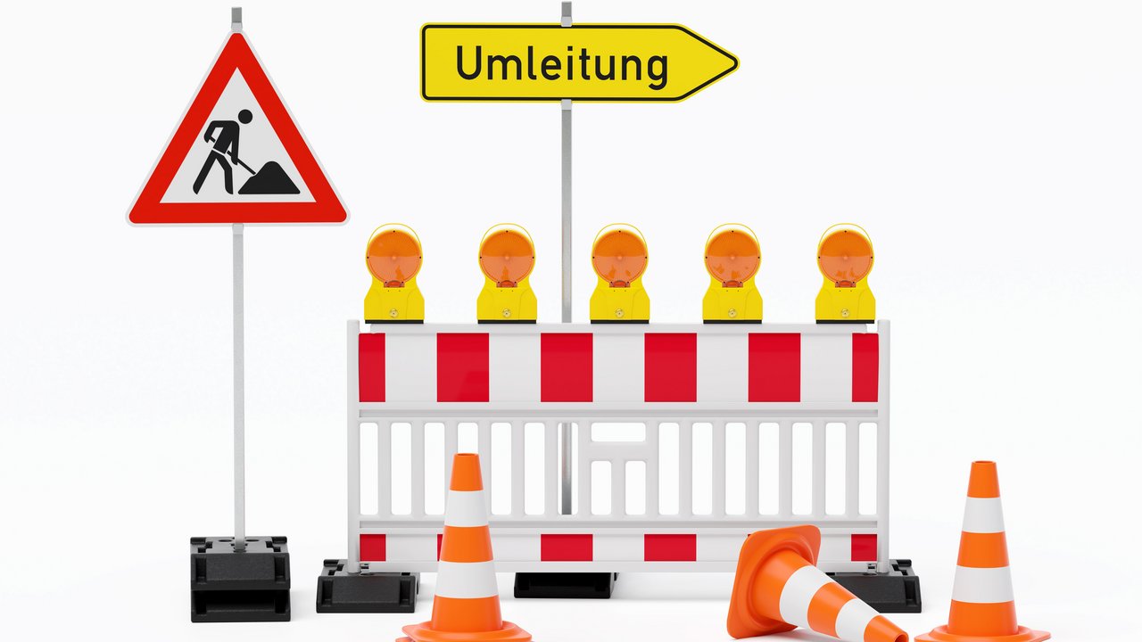 Einzelne Absturzsicherung mit 5 Bakenleuchten gelb-orange, Fußplatten, Schild Baustelle, Schild Umleitung rechtsweisend auf Pfosten steht daneben und Verkehrshütchen Pylone - freigestellt 